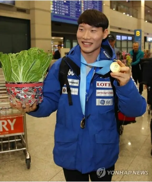 仁川空港でハクサイと金メダルを掲げる李＝２１日、仁川（聯合ニュース）