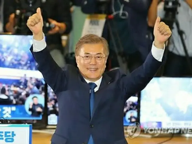 出口調査の結果を受け笑顔を見せる文氏＝９日、ソウル（聯合ニュース）