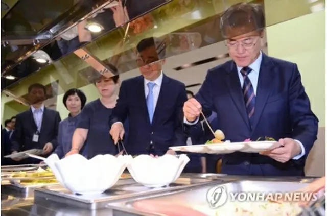 職員食堂でプレートに料理を盛る文大統領（右端）＝１２日、ソウル（聯合ニュース）