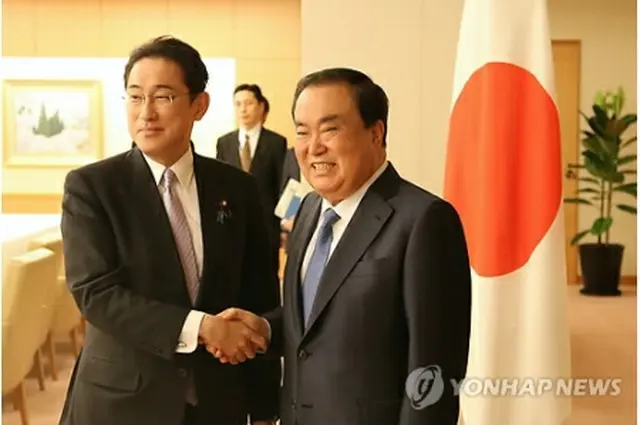 握手を交わす文氏（右）と岸田氏＝１７日、東京（聯合ニュース）