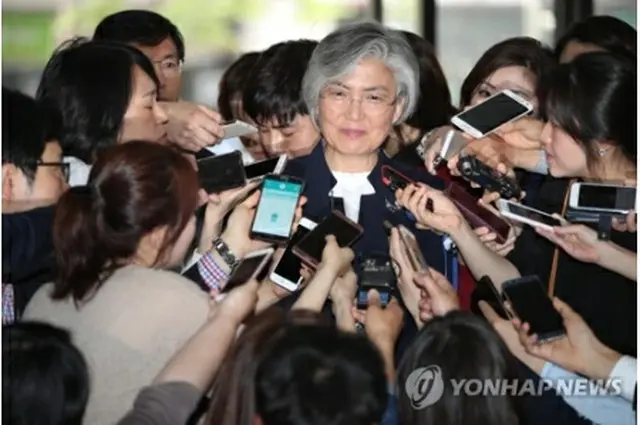 外交部近くの臨時事務所に到着し、記者団の質問に答える康氏＝２５日、ソウル（聯合ニュース）