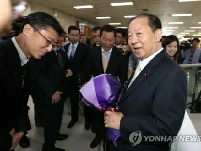 金浦空港に到着した二階氏(右)=10日、ソウル(聨合ニュース)