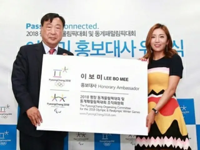 平昌五輪組織委員会の李熙範（イ・ヒボム）委員長から広報大使の名刺を受け取るイ・ボミさん（右、組織委提供）＝２７日、ソウル（聯合ニュース）