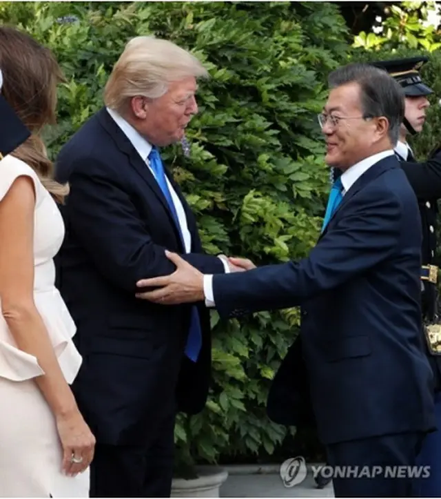 ホワイトハウスの玄関で握手を交わす文大統領（右）とトランプ大統領＝２９日、ワシントン（聯合ニュース）