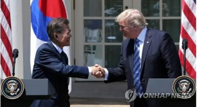 記者会見で握手を交わす文大統領（左）とトランプ大統領＝３０日、ワシントン（聯合ニュース）