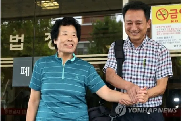 判決を受けて地裁前で笑顔を見せる原告の女性＝８日、光州（聯合ニュース）
