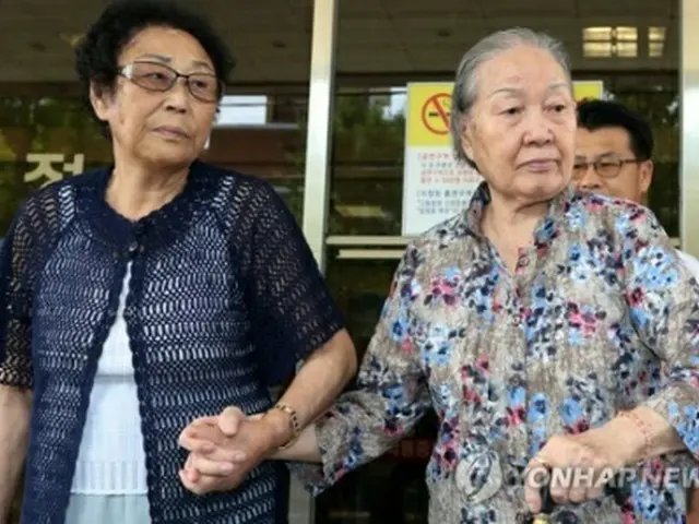 地裁を出る原告の女性（右）＝１１日、光州（聯合ニュース）