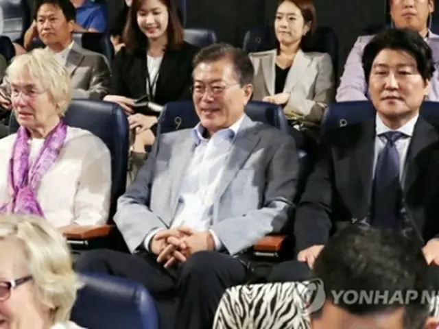 文大統領（中央）はソン・ガンホ氏（右端）やユルゲン・ヒンツペーター氏夫人と並んで映画を鑑賞した＝１３日、ソウル（聯合ニュース）