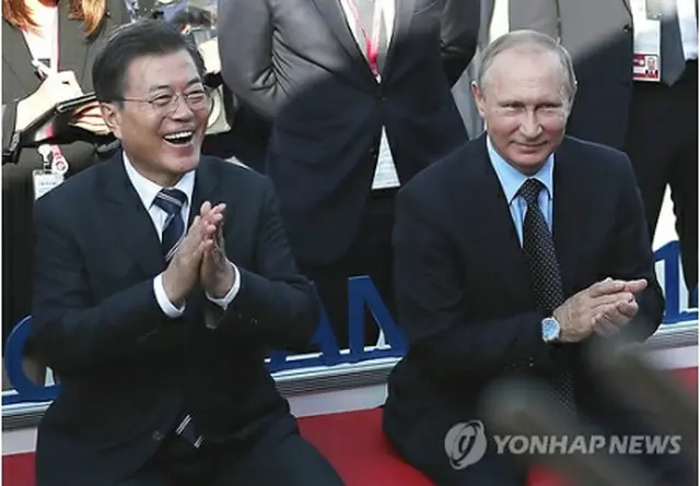 会談後、ウラジオストクの市内を散歩する文大統領（左）とプーチン大統領＝６日、ソウル（聯合ニュース）