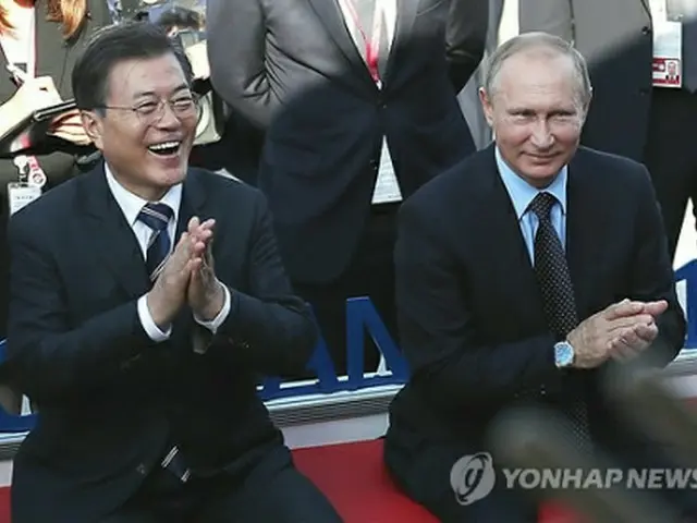 会談後、ウラジオストクの市内を散歩する文大統領（左）とプーチン大統領＝６日、ソウル（聯合ニュース）