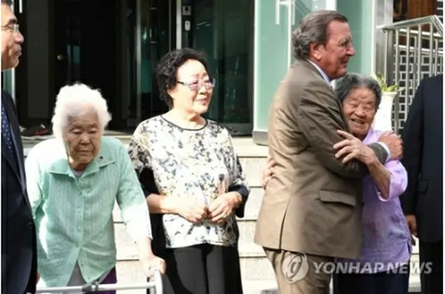 慰安婦被害者と抱き合うシュレーダー氏＝１１日、広州（聯合ニュース）