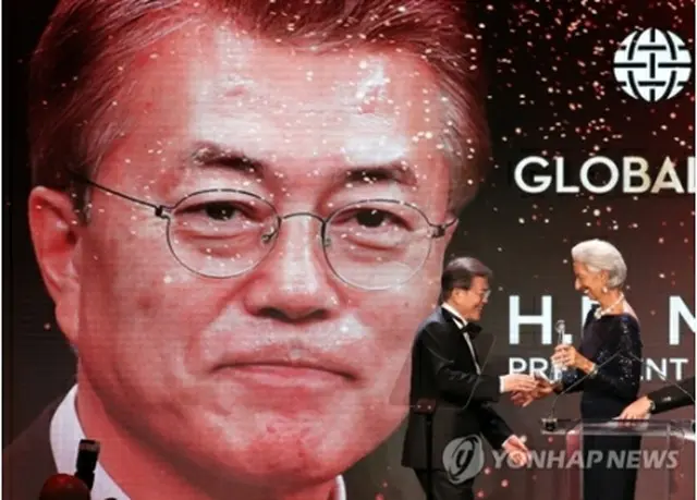 国際通貨基金（ＩＭＦ）のラガルド専務理事から賞を受け取る文大統領（左）＝１９日、ニューヨーク（聯合ニュース）