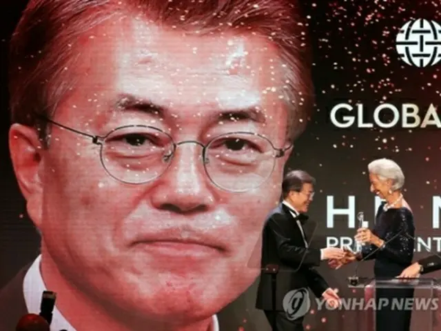 国際通貨基金（ＩＭＦ）のラガルド専務理事から賞を受け取る文大統領（左）＝１９日、ニューヨーク（聯合ニュース）