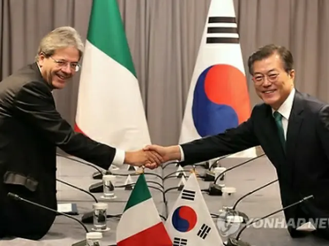 握手を交わす文大統領（右）とジェンティローニ首相＝２０日、ニューヨーク（聯合ニュース）