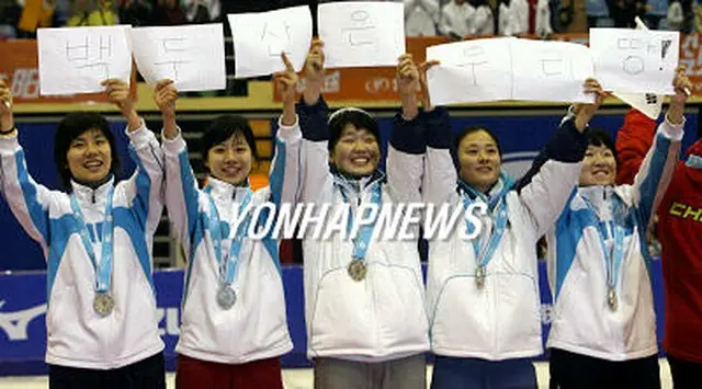 「白頭山は韓国の領土」と書かれた紙を掲げるショートトラック女子の韓国代表選手＝1日、長春（聯合）