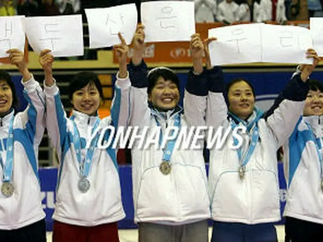 「白頭山は韓国の領土」と書かれた紙を掲げるショートトラック女子の韓国代表選手＝1日、長春（聯合）