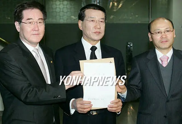 ソウル中央地検で柳時敏保健福祉部長官に対する告訴状を掲げてみせる医師協会側＝21日、ソウル（聯合）