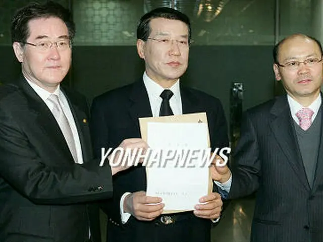 ソウル中央地検で柳時敏保健福祉部長官に対する告訴状を掲げてみせる医師協会側＝21日、ソウル（聯合）