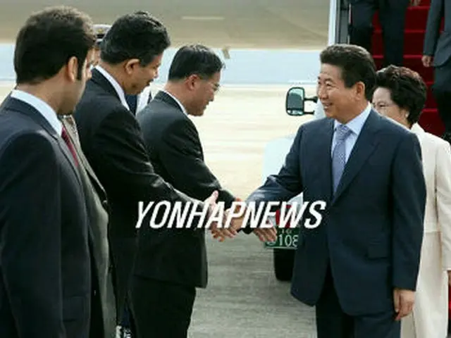 ソウル空港に到着し、歓迎を受ける盧武鉉大統領＝30日、城南（聯合）