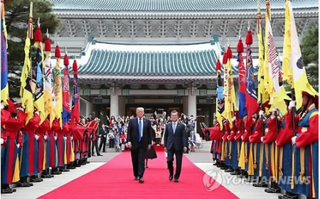 歓迎式のため青瓦台の大庭園に向かう文大統領（右）とトランプ大統領＝７日、ソウル（聯合ニュース）