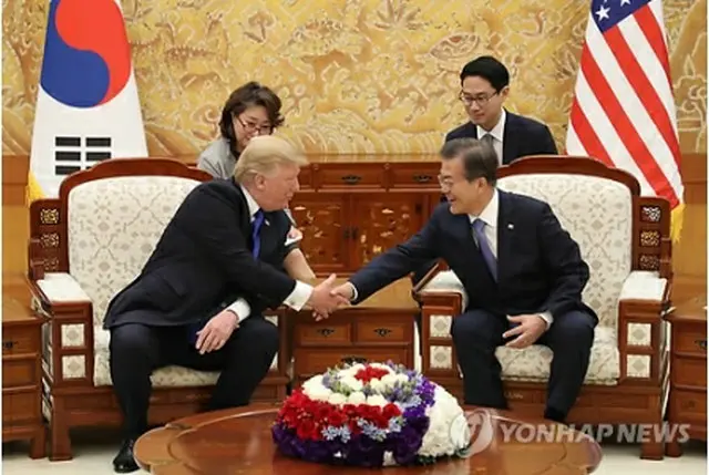 首脳会談を前に握手を交わす文大統領（右）とトランプ大統領＝７日、ソウル（聯合ニュース）