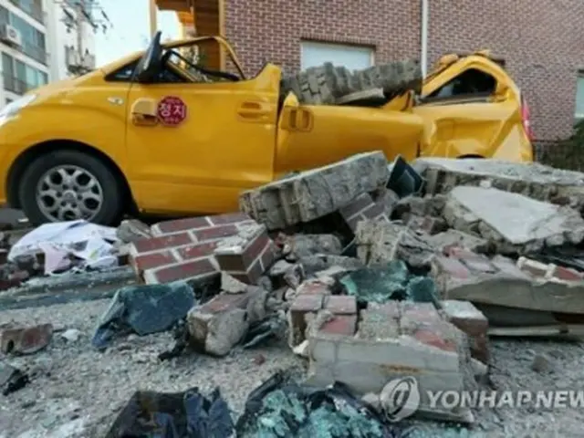 保育園の壁が崩れてつぶれた車両＝１５日、浦項（聯合ニュース）