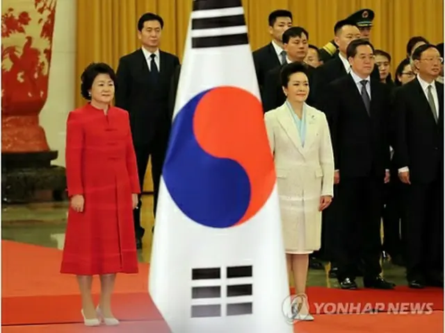 北京の人民大会堂で開かれた文在寅（ムン・ジェイン）韓国大統領の公式歓迎式で、文大統領夫人の金正淑（キム・ジョンスク）氏（左）と習近平国家主席の夫人、彭麗媛氏が並んでいる＝１４日、北京（聯合ニュース）(END)