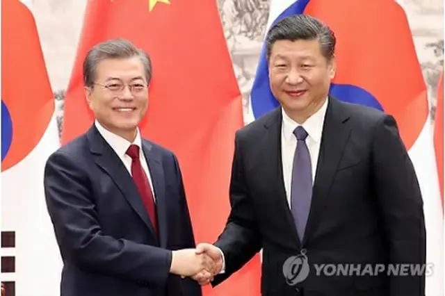 １２月１４日、中国・北京で首脳会談を行った文大統領（左）と習近平国家主席＝（聯合ニュース）