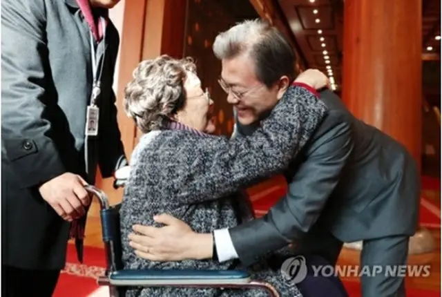 昼食会に出席した慰安婦被害者と抱き合う文大統領（青瓦台提供）＝４日、ソウル（聯合ニュース）