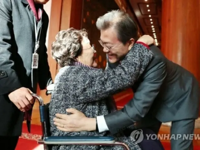 昼食会に出席した慰安婦被害者と抱き合う文大統領（青瓦台提供）＝４日、ソウル（聯合ニュース）
