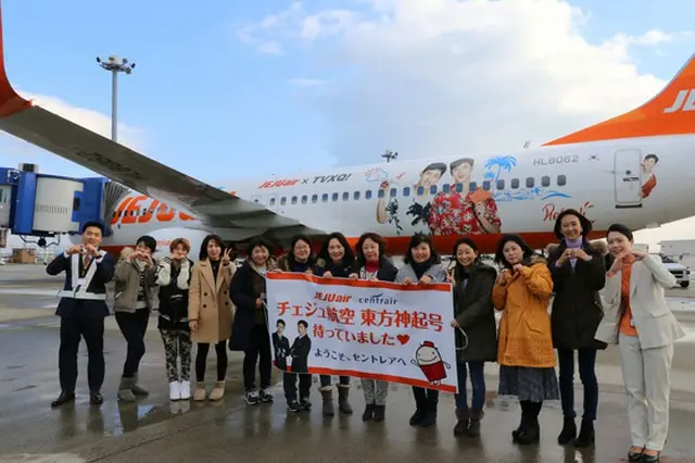 先日1月6日に名古屋中部国際空港に招待された「東方神起」の日本ファンたちがチェジュ航空の東方神起ラッピング機前で記念撮影をしている。（オフィシャル）