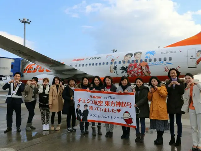 先日1月6日に名古屋中部国際空港に招待された「東方神起」の日本ファンたちがチェジュ航空の東方神起ラッピング機前で記念撮影をしている。（オフィシャル）