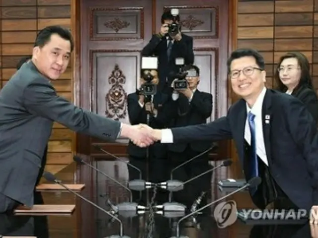 握手を交わす韓国統一部の李柱泰（イ・ジュテ）交流協力局長（右）と北朝鮮・祖国平和統一委員会の黄忠誠（ファン・チュンソン）部長（統一部提供）＝２７日、板門店（聯合ニュース）
