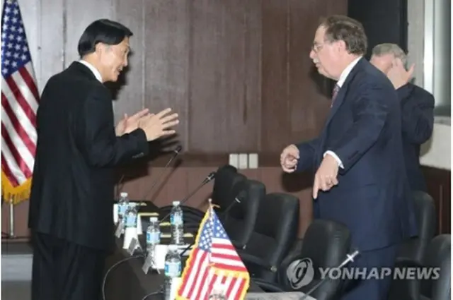 協議前に言葉を交わす張氏（左）とベッツ氏＝１１日、西帰浦（聯合ニュース）
