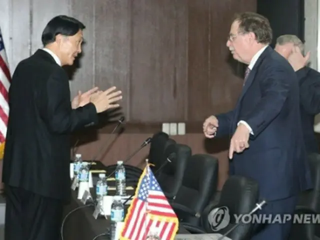 協議前に言葉を交わす張氏（左）とベッツ氏＝１１日、西帰浦（聯合ニュース）