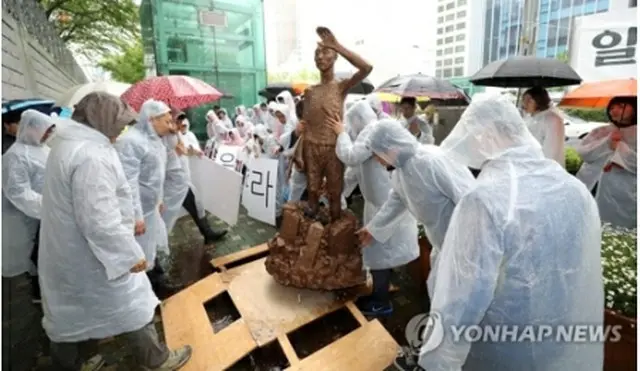 市民団体が行った総領事館前に像の模型を設置するパフォーマンスの様子＝２４日、釜山（聯合ニュース）