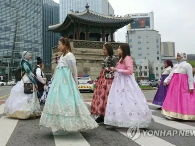 韓国の伝統衣装「韓服」を着てソウル市内を歩く外国人観光客＝（聯合ニュース）