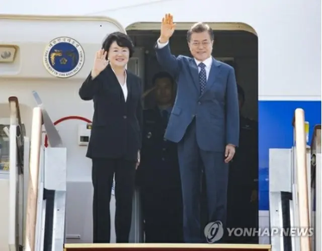 出発前、夫人とともに手を振る文大統領＝２１日、城南（聯合ニュース）