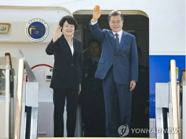 出発前、夫人とともに手を振る文大統領=21日、城南(聯合ニュース)