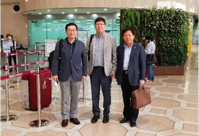 金浦空港を出発する金弘傑氏（中央、民和協提供）＝１４日、ソウル（聯合ニュース）