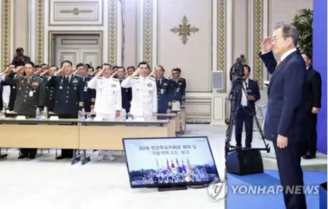青瓦台で開催された全軍主要指揮官会議で出席者から敬礼を受ける文大統領＝２７日、ソウル（聯合ニュース）