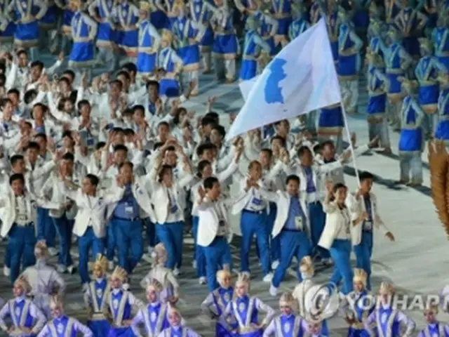 朝鮮半島旗を掲げて入場する南北の選手たち＝１８日、ジャカルタ（聯合ニュース）