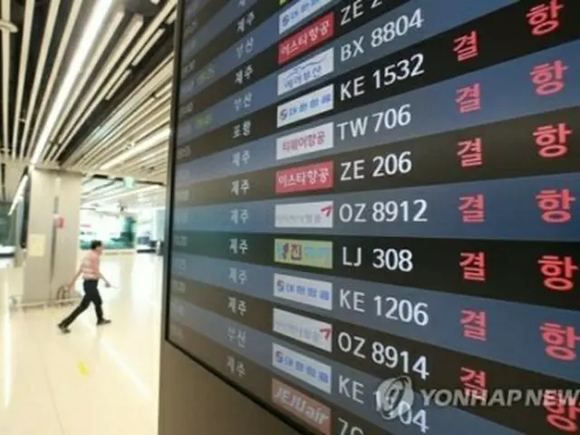 欠航を知らせる金浦空港の電光掲示板＝２３日、ソウル（聯合ニュース）