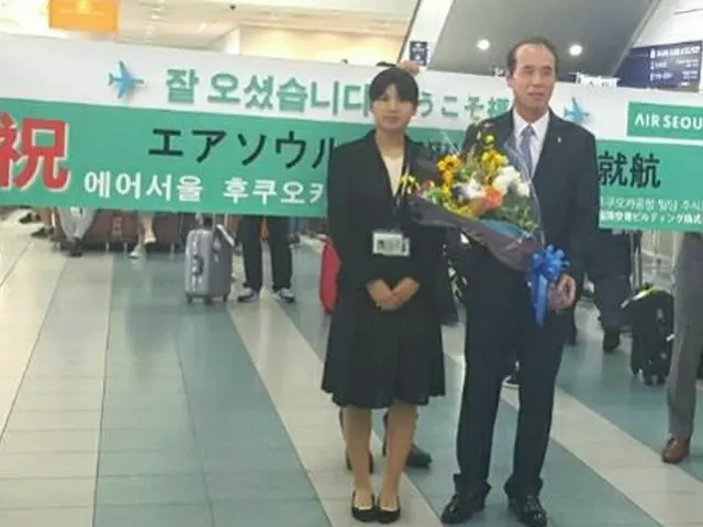 福岡空港ビルディング関係者より、エアソウル代表取締役社長チョ・ギュヨン氏へ花束を贈呈。（オフィシャル）