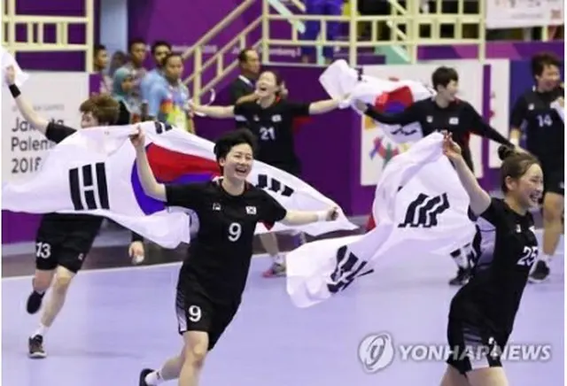 金メダルを獲得したハンドボール女子韓国代表の選手たちが国旗を手に笑顔を見せている＝８月３０日、ジャカルタ（聯合ニュース）