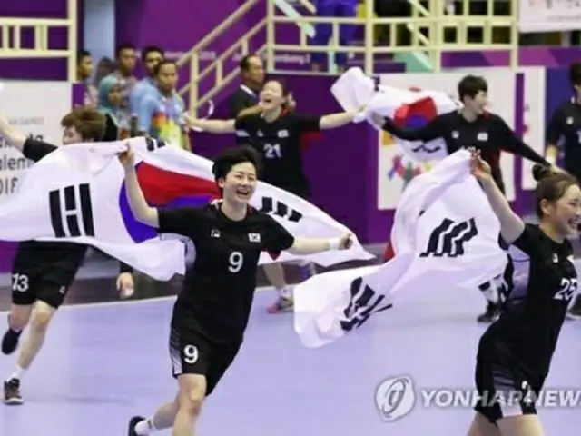 金メダルを獲得したハンドボール女子韓国代表の選手たちが国旗を手に笑顔を見せている＝８月３０日、ジャカルタ（聯合ニュース）