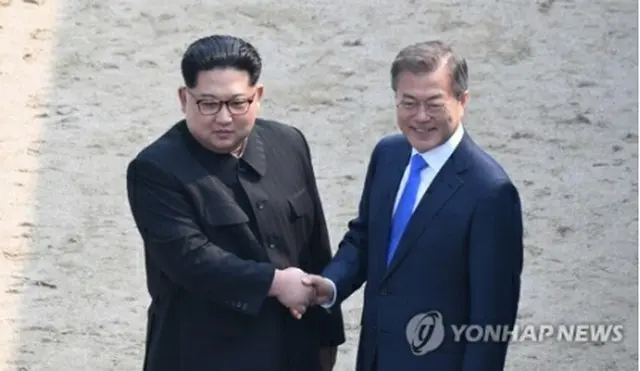 ４月２７日、軍事境界線を越え、北朝鮮側で握手を交わす文大統領（右）と金委員長＝（聯合ニュース）