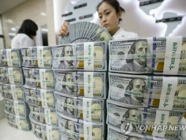 ドル紙幣を数える銀行員（資料写真）＝（聯合ニュース）