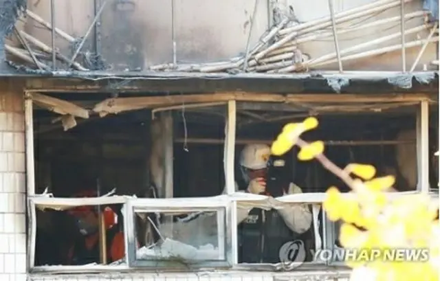 火災があった建物の内部で鑑識作業を行う関係者＝（聯合ニュース）