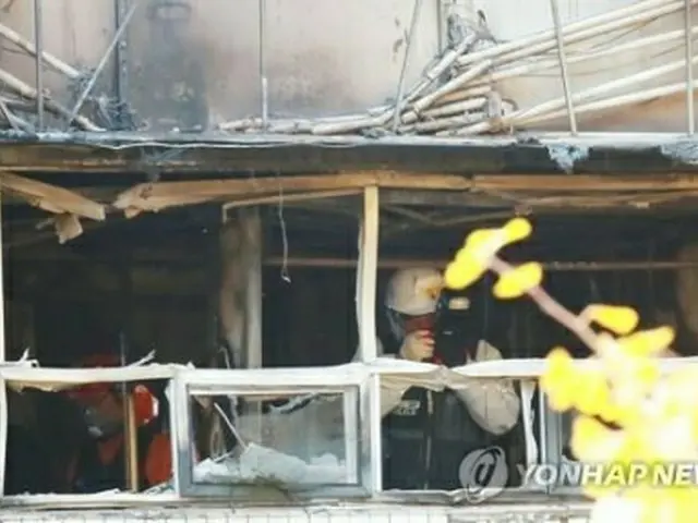 火災があった建物の内部で鑑識作業を行う関係者＝（聯合ニュース）